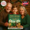 A family smiling while holding the John Deere Advent Calendar 2025 in front of a Christmas tree.