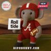 A crochet elephant plushie with a red football uniform on a field!