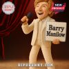 Barry Manilow collectible doll in cream suit holding microphone and name sign with stage curtain background.