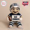 Crochet Cowboys football doll holding sign and ball on beige background.
