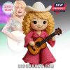 A crochet doll of a blonde woman in a pink outfit holding a guitar!