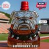 Bulldog-shaped liquor bottle with a red hat-style cap on a stadium field.