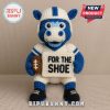 A crocheted cow mascot wearing a football uniform and holding a football and a sign!