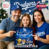 Family holding Dodgers advent calendar with joyful expressions, sharing holiday fun.