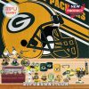 Green Bay Packers merchandise and figurines laid out on wood with large team logo in background!