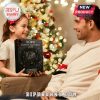 Father and daughter happily holding the Korn Advent Calendar 2025 in front of a Christmas tree.