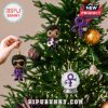 Prince-themed ornaments including a figure with a guitar and a purple symbol hanging on a Christmas tree.
