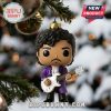 Close-up of a Prince figure ornament with a guitar, hanging on a Christmas tree.
