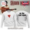 White crewneck sweater with red heart on front and Shawn Mendes 2025 tour dates on back.