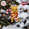 Pooh ornament with candy cane hanging on Christmas tree.