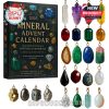 The advent calendar features 24 gemstone-themed ornaments or charms, including cut gems, polished stones, and raw mineral formations, each set in golden hooks and paired with a deluxe collector’s box!
