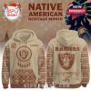 Tan Raiders hoodie featuring tribal sleeve art, dreamcatcher front logo, and detailed tomahawk print on back!