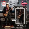 Bob Dylan action figure with hat and electric guitar posed on a display base next to branded box and digital render background!