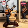 Seated Bob Dylan figurine strumming acoustic guitar in armchair beside matching retro box and modeling screen background!