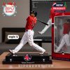 Rafael Devers figurine in a batting pose, with a bat, mounted on a stand and displayed in a product box.