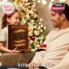 A cheerful girl gives the Outlander calendar to her dad in a warmly lit room with a Christmas tree, emphasizing the calendar’s size and appeal as a thoughtful gift!