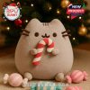 Pusheen holding a candy cane, surrounded by festive candy and a Christmas tree in the background.