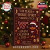 Virginia Tech Advent Calendar 2025 placed in front of a Christmas tree, with festive lighting in the background.