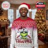 Man in Atlanta Falcons Grinch Christmas sweater standing in festive living room.