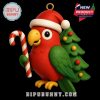 A festive red parrot with green wings holds a candy cane while standing in front of a Christmas tree, creating a joyful holiday character ornament!