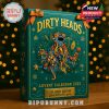 A close-up of the Dirty Heads calendar with vivid tropical illustrations and glowing holiday accents on a wooden holiday table setting.