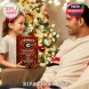 Holiday gift-giving scene with a child handing over the Georgia Bulldogs Advent Calendar 2025 near a glowing Christmas tree.