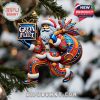 A colorful Santa Claus ornament branded with Greta Van Fleet hangs from a Christmas tree, combining rock and holiday cheer.