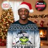Man modeling a Texans-themed Grinch ugly Christmas sweater, surrounded by classic holiday decorations in a warmly lit room!