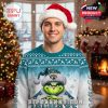 Man modeling a Jaguars Grinch holiday sweater, standing in a cozy room with a decorated tree and warm Christmas lighting!