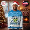 A smiling man wears a Chargers-themed Christmas sweater with the Grinch on it, set in a holiday-decorated living room with a lit fireplace and Christmas tree!