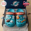 Miami Dolphins-themed Crocs with sports charms in branded box on wood surface!