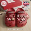 Nebraska Cornhuskers Crocs in red with football-themed charms in branded box on wooden surface!