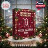 Holiday-themed Oklahoma Sooners 2025 advent calendar placed in a festive winter setting with snowy trees and stadium lights!