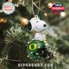 Holiday ornament of Snoopy sitting on a green Oregon helmet, designed for tree decoration, captures team spirit and Peanuts charm!