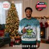 A man wearing a Philadelphia Eagles Grinch Ugly Christmas Sweater stands in a holiday-decorated living room with a Christmas tree and fireplace behind him!