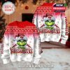 Front and back of red and white Grinch Buccaneers Christmas sweater shown together in a cozy holiday-decorated room!