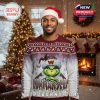 Black man in Commanders Grinch Christmas sweater and Santa hat standing in festive room with Christmas tree and fireplace!