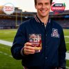 Arizona Wildcats fan in navy jacket holding 126th Anniversary whiskey glass with cactus details at football stadium!