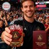 Fan celebrating in crowd with Atlanta United FC whiskey glass and commemorative packaging, surrounded by game-day atmosphere.