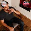 Atlanta United fan enjoying a drink from commemorative whiskey glass in home setting, highlighting team pride and comfort.