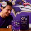 Fan admiring Baltimore Ravens whiskey glass and matching box with detailed design and team tribute on wooden table!