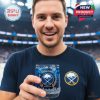 A Buffalo Sabres supporter enjoying a commemorative whiskey glass during a hockey event!