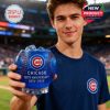 A cheerful supporter shows off the Chicago Cubs whiskey glass in front of a stadium crowd, highlighting its vivid color and bold design!