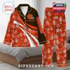 Cleveland Browns-themed pajamas on a bed with orange tones, team graphics, and white flower patterns for fans!