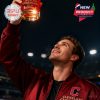 A sports fan holding up a red whiskey glass with the Cleveland Guardians logo while gazing upward during a night game!
