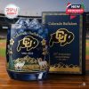 A celebratory whiskey glass with Colorado Buffaloes branding, showcasing golden floral designs, mountain rams, and commemorative years 1890-2026, set against a sports stadium backdrop!
