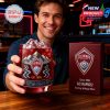 Man smiling and holding a Colorado Rapids whiskey glass with ice in a stylish bar setting with team themed decor!