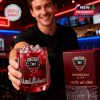 Smiling fan in bar handing forward D.C. United whiskey glass filled with red drink, gift box proudly displayed next to him!
