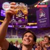 An energetic game day scene featuring a raised East Carolina Pirates anniversary whiskey glass among cheering fans!