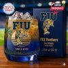 FIU whiskey glass with panther logo, palm trees, and commemorative box in background.